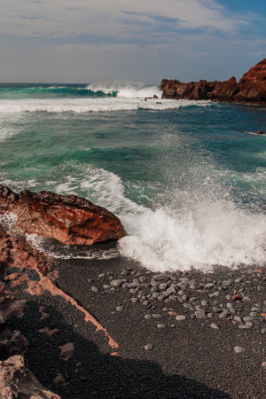 Volcanic Lanzarote island scenery. aerial panoramic drone view of Los Hervideros caves and cliffs and Red mountain. popular tourist destination Canary islandsの写真素材