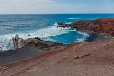 Volcanic Lanzarote island scenery. aerial panoramic drone view of Los Hervideros caves and cliffs and Red mountainの写真素材