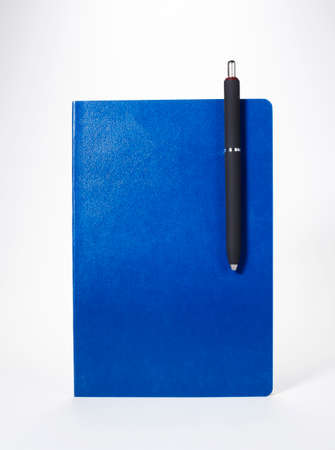 Notebook with a pen on white background