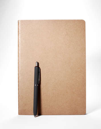 Notebook with a pen on white background