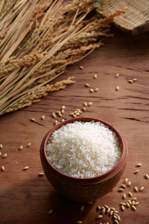 Raw rice in a pot on wooden backgroundの写真素材