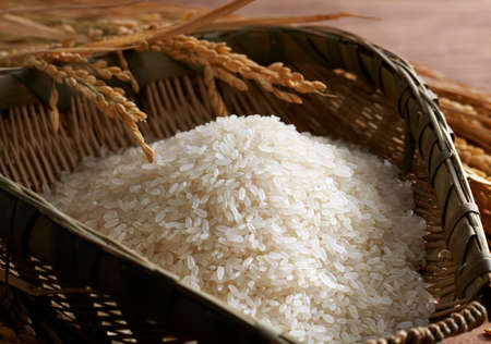 Rice in dustpan on wooden backgroundの写真素材