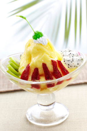 vanilla ice cream with strawberries and passion fruit in a glass bowlの写真素材