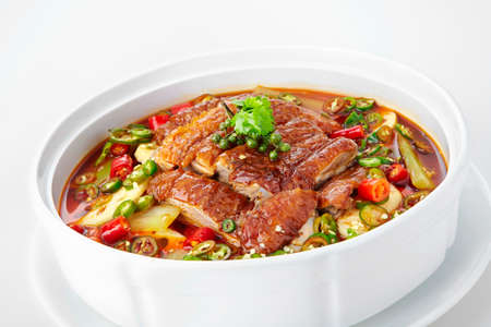 Pork in spicy soup with chili and green pepper on white background