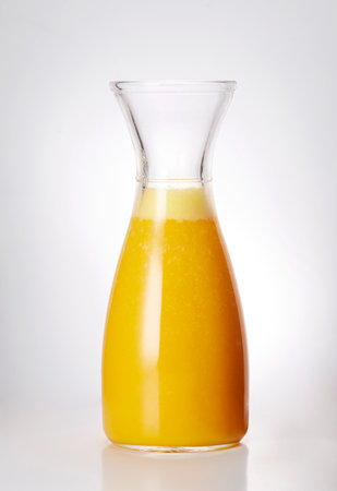 Orange juice in a glass decanter on a white background.の写真素材