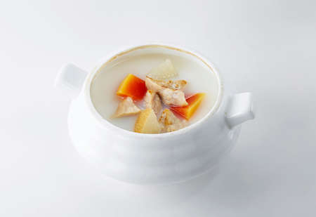 Chicken soup in a white porcelain bowl on a white backgroundの写真素材