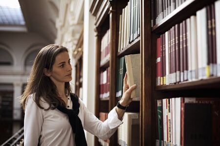 Student looking for a book in library.の写真素材