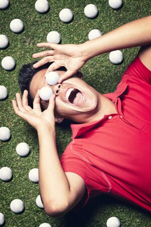 Golf player on floor with balls on eyes.の写真素材