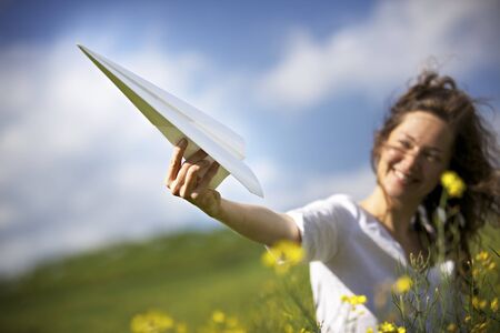 Happy girl playing with paper planeの写真素材