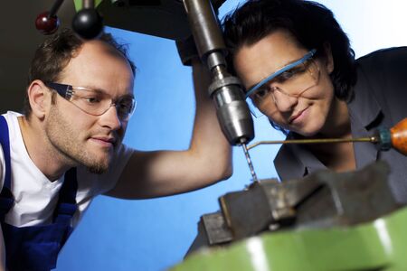 Technicians drilling in workshopの写真素材
