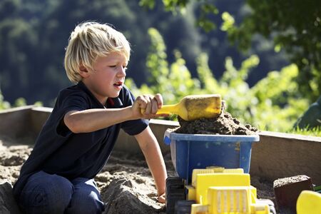 Boy playing in sandbox.