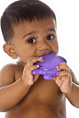 Sweet Indian baby chewing on toyの写真素材
