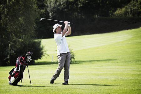 Golfer pitching at golf course.の写真素材