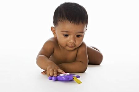 Sweet Indian baby playing on floorの写真素材
