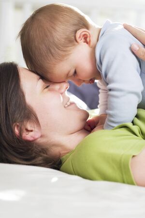 Tender moments: Joyful mother embracing her son with love.の写真素材
