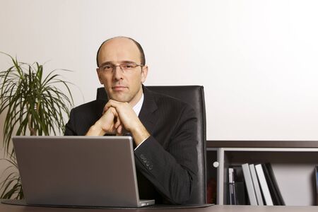 Businessman at laptop in officeの写真素材