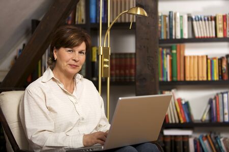 Attractive senior woman sitting with laptopの写真素材