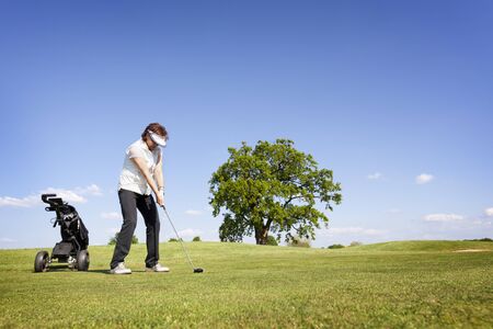 Woman focusing on golf fairway.の写真素材