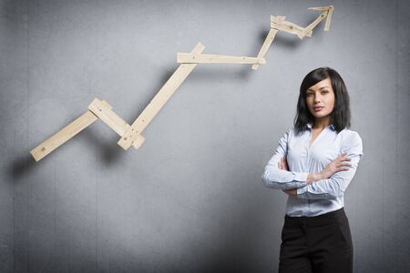 Confident successful businesswoman in front of positive trend chart.の写真素材