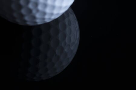 Golf ball with reflection isolated on black background.の写真素材
