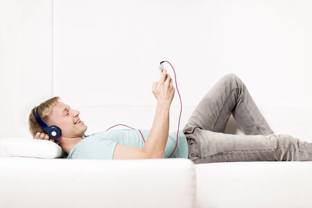 Joyous man listening to music with earphones and resting.