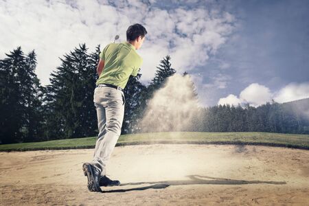 Young golfer in sand trap.の写真素材