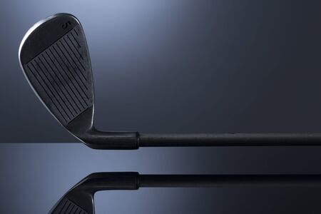 Golf club isolated on dark blue reflective background.