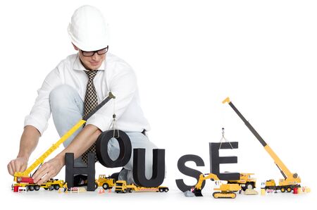 House under construction concept: Smiling engineer building the word house along with construction machines, isolated on white background.の写真素材