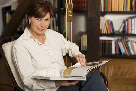 Sweet senior woman sitting and reading a bookの写真素材