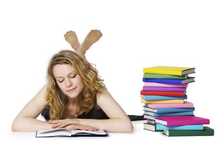 Girl lying on floor and reading, looking at bookの写真素材