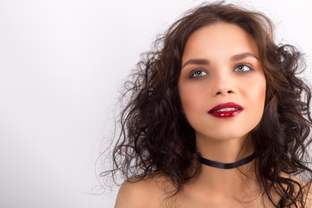 Beauty Model Woman with Long Brown Wavy Hair. Healthy Hair and Beautiful Professional Makeup. Red Lips and Smoky Eyes Make up.の写真素材