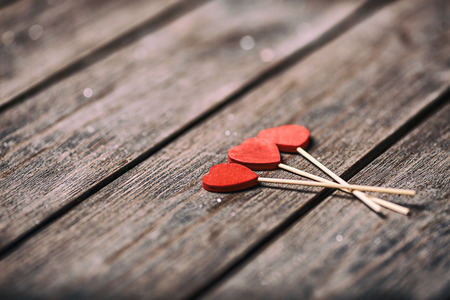 Three red hearts shape on stick over wooden background. Valentine concept. selective focus.の写真素材