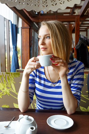 beautiful young girl restingin a cafe and looking out the window. Selective focus.の写真素材