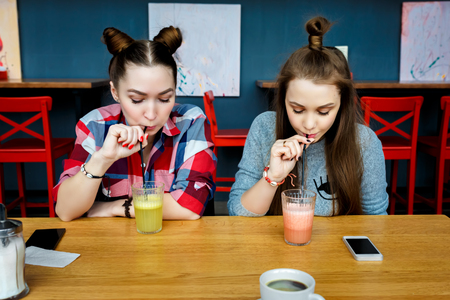 Young girls having fun in a cafe barの写真素材