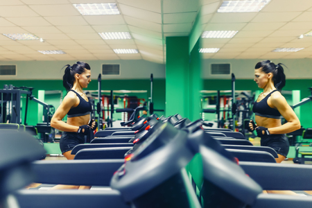Young fitness woman doing cardio exercises at the gym running on a treadmill female runner training at the gim.の写真素材