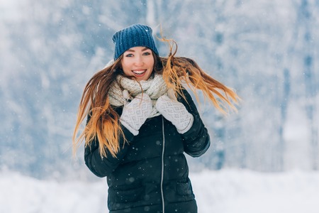 Winter young woman portrait. Beauty Joyful Model Girl laughing and having fun in winter park. Beautiful young woman outdoors. Enjoying nature, wintertimeの写真素材