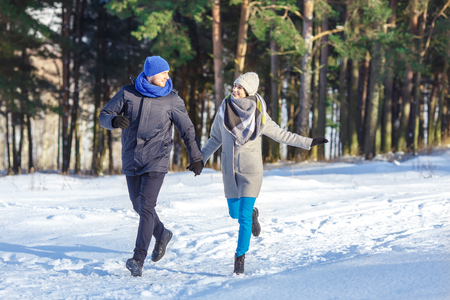 Happy Young Couple in Winter Park laughing and having fun. Family Outdoors.の写真素材