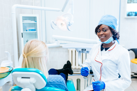 African american female dentist treating patient at clinic. Dental clinic concept.の写真素材