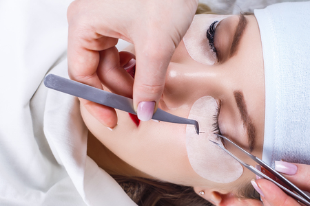 Eyelash Extension Procedure. Woman Eye with Long Eyelashes. Lashes, close up, selected focus.の写真素材