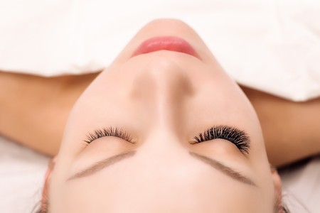 Eyelash Extension Procedure. Woman Eye with Long Eyelashes. Close up, selective focus.の写真素材