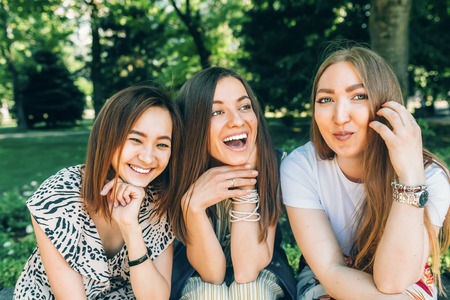 Summer lifestyle portrait multiracial women enjoy nice day. Happy friends in the park on a sunny day. Best friends girls having fun, joy. Lifestyle. Asian, jewess and caucasian.の写真素材