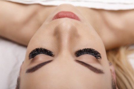 Eyelash Extension Procedure. Woman Eye with Long Eyelashes. Close up, selective focus. Hollywood, russian volumeの写真素材