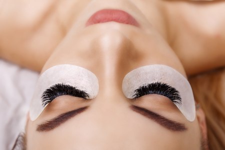 Eyelash Extension Procedure. Woman Eye with Long Eyelashes. Close up, selective focus. Hollywood, russian volumeの写真素材