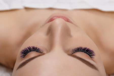 Eyelash Extension Procedure. Woman Eye with Long Blue Eyelashes. Ombre effect. Close up, selective focus.の写真素材