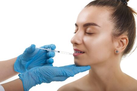 Facial Beauty Injections. Portrait Beautiful Young Woman Receiving Hyaluronic Acid Injection. Closeup Of Hands In Gloves Holding Syringe Near Attractive Female Face.の写真素材