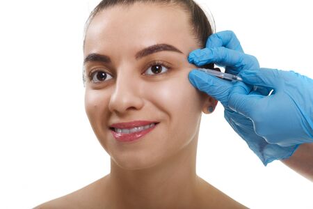Closeup Beautician Hands Doing Facial Skin Lifting Injection To female. Beautiful young woman face and hand in glove with syringe making injection.の写真素材
