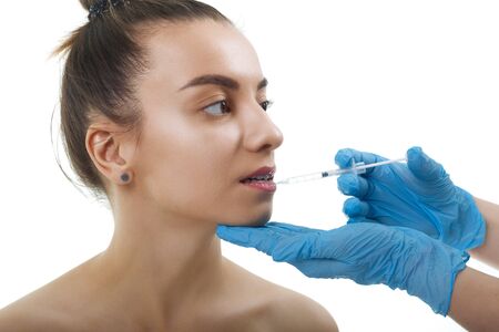 Facial Beauty Injections. Portrait Beautiful Young Woman Receiving Hyaluronic Acid Injection. Closeup Of Hands In Gloves Holding Syringe Near Attractive Female Face.の写真素材