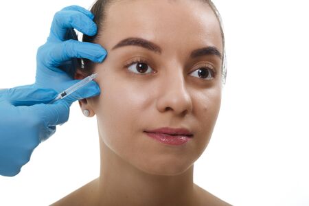 Closeup Beautician Hands Doing Facial Skin Lifting Injection To female. Beautiful young woman face and hand in glove with syringe making injection.の写真素材