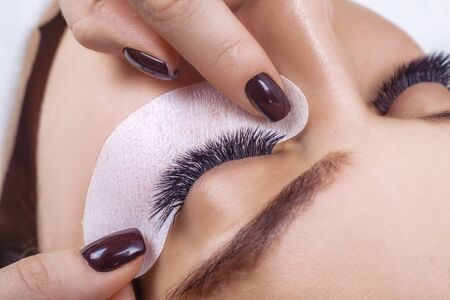 Eyelash Extension Procedure. Woman Eye with Long Blue Eyelashes. Ombre effect. Close up, selective focus.の写真素材
