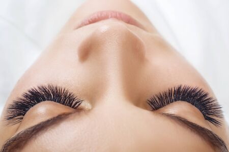 Eyelash Extension Procedure. Woman Eye with Long Blue Eyelashes. Ombre effect. Close up, selective focus.の写真素材